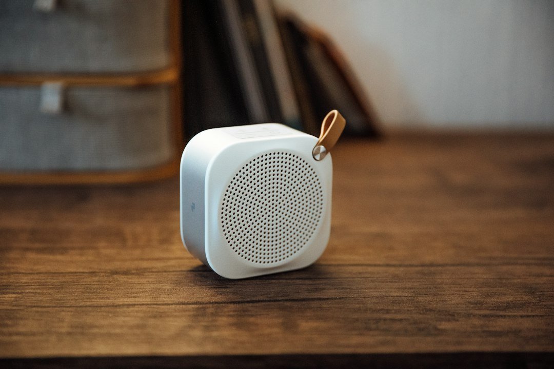 Altavoz portátil blanco sobre una mesa de madera