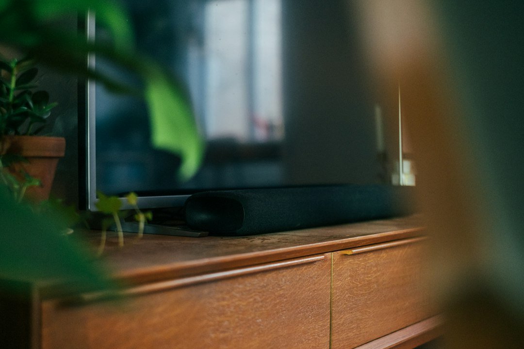 Altavoz doméstico en una mesa de salón junto a un móvil
